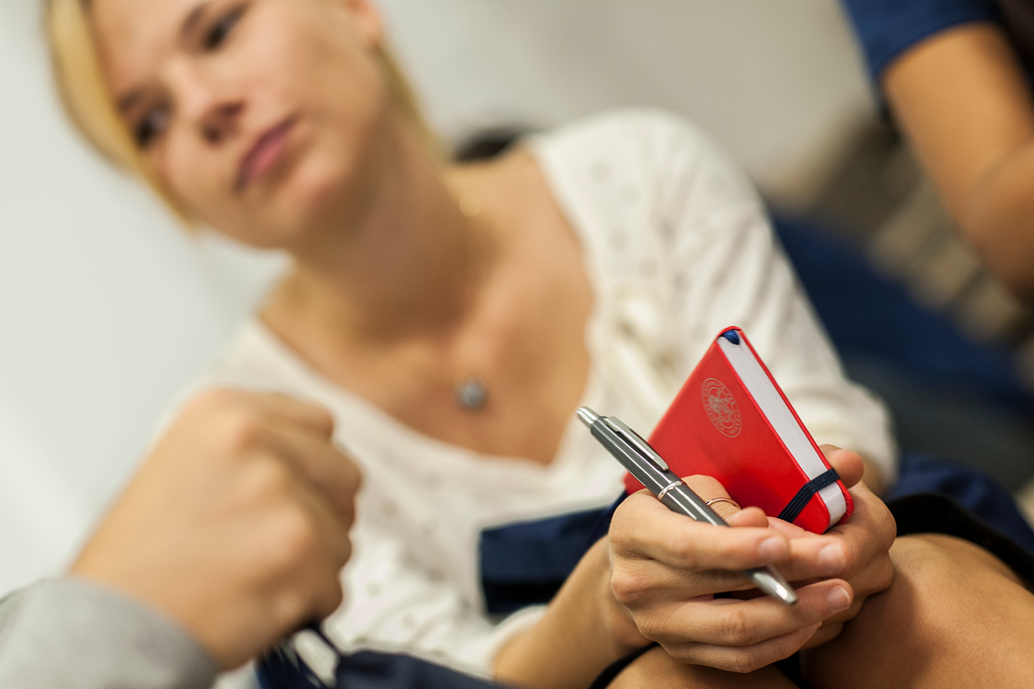 giovane donna che reca in mano un taccuino e una penna