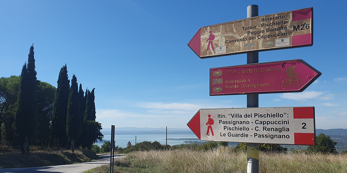 frecce lungo un sentiero e lago sullo sfondo