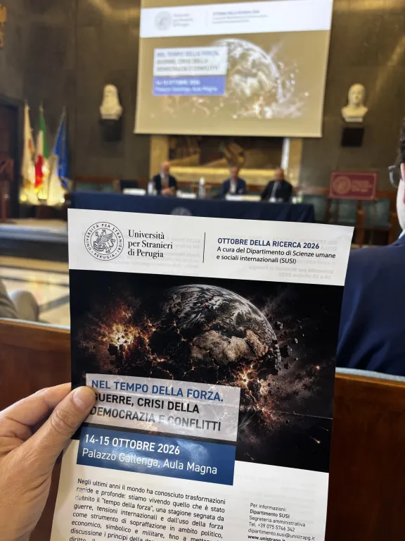 au premier plan, le programme de l'&eacute;v&eacute;nement, en arri&egrave;re-plan la table des intervenants