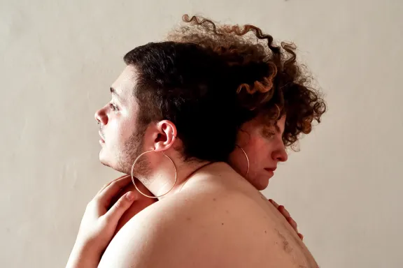 ragazzo che indossa grandi orecchini a cerchio e abbraccia una ragazza