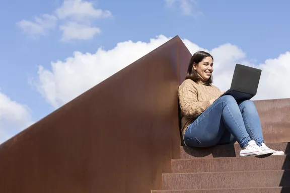 ragazza che guarda sorridente un computer