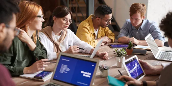 giovani che lavorano assieme attorno a un tavolo